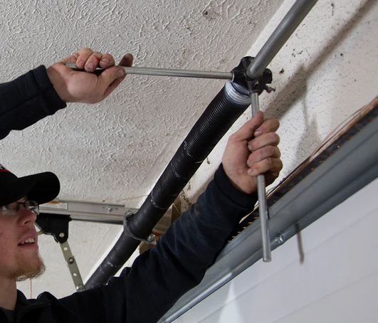 a garage door with a technician repairing a broken spring; essential service provided by Garage Door Repair Services Cloud FL for ensuring safety and functionality.